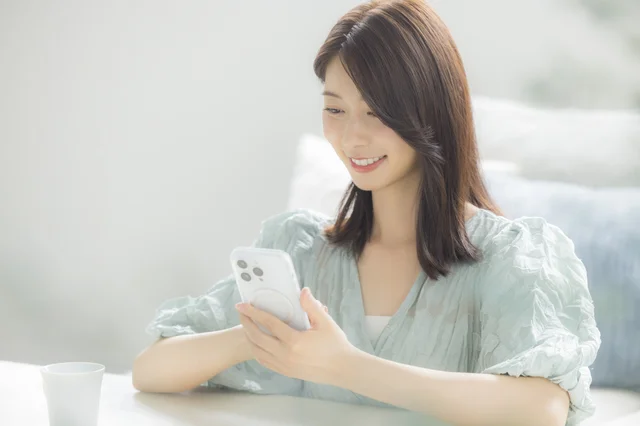 笑顔でスマホを操作する女性